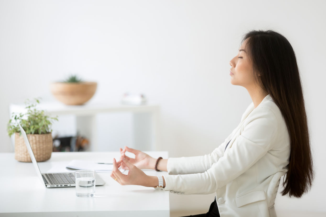 Woman meditating at office desk