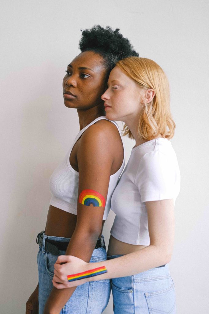 An LGBTQ+ couple with rainbow body paint for Pride Month 2022