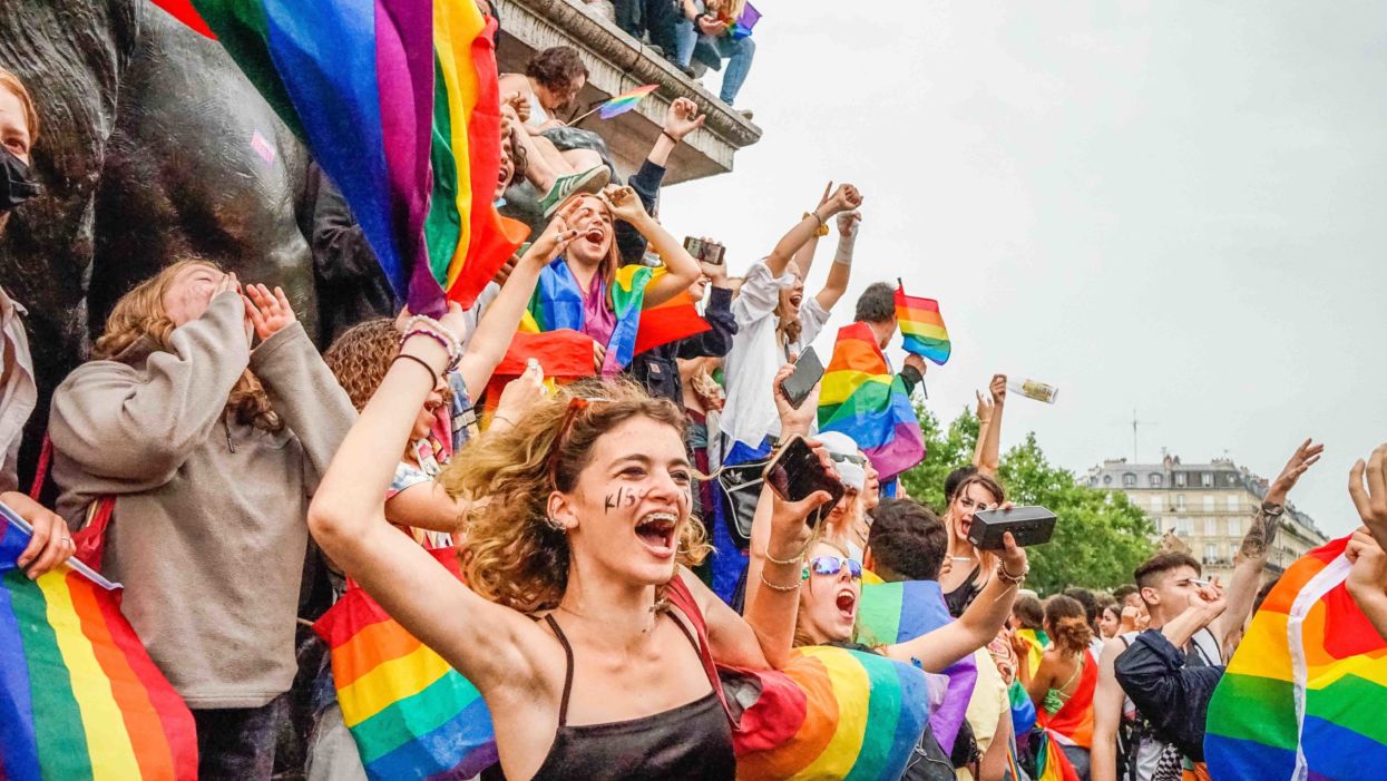 Marchers celebrate Pride Month 2022 at a pride parade with colorful rainbow flags