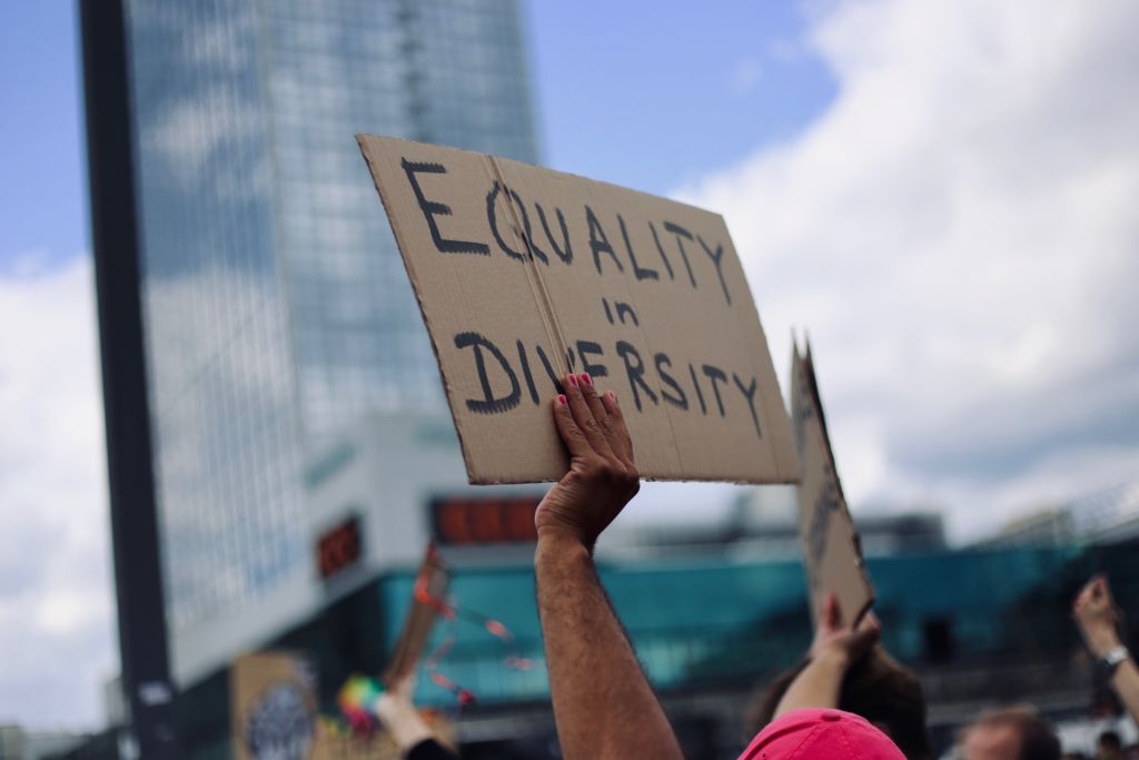 A protest sign reads, "equality and diversity." Advertising stereotypes can undermine equity efforts.