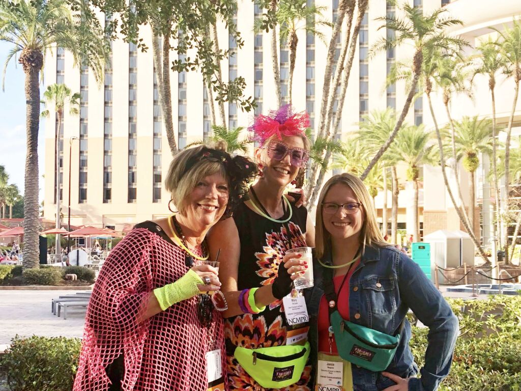 Diane, Mary, and Jamie show off their 80s costumes at the NCMPR 2023 conference.