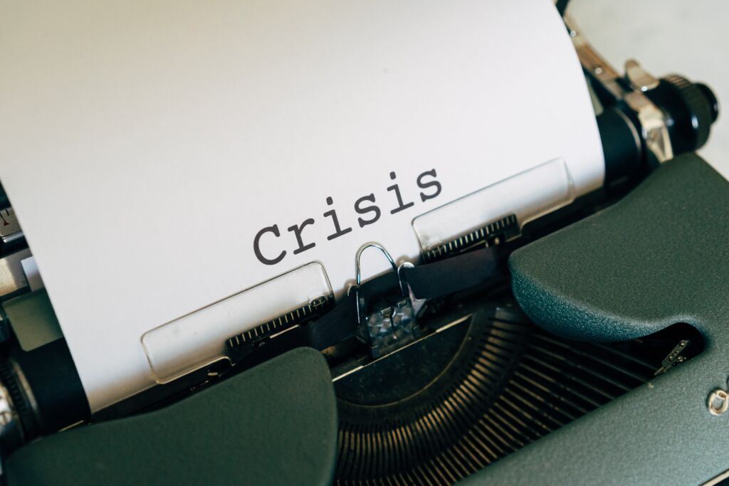 A typewriter types the word crisis for crisis communication.
