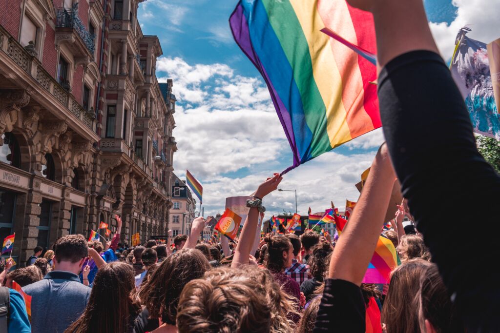 Photo of rainbow flags at an LGBTQ Pride parade.