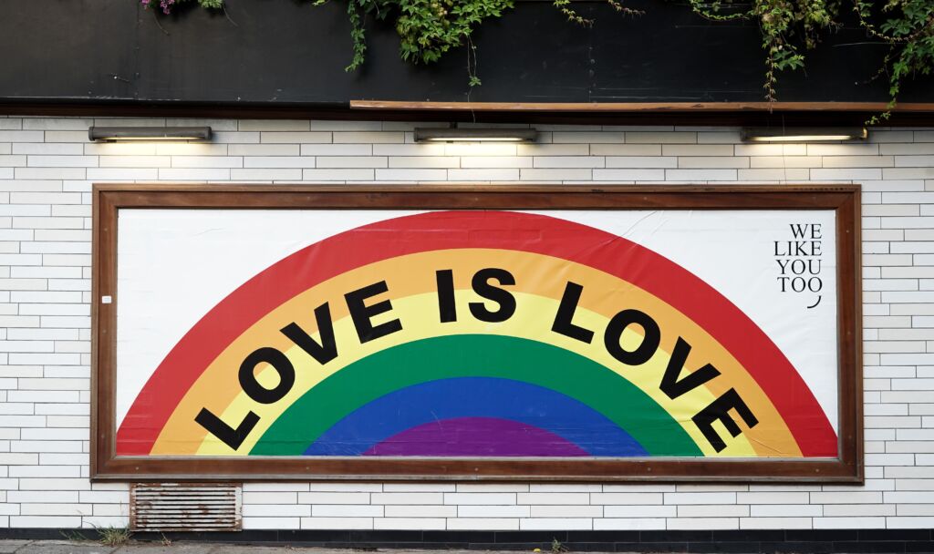 A rainbow LGBTQ mural reads "Love is love."
