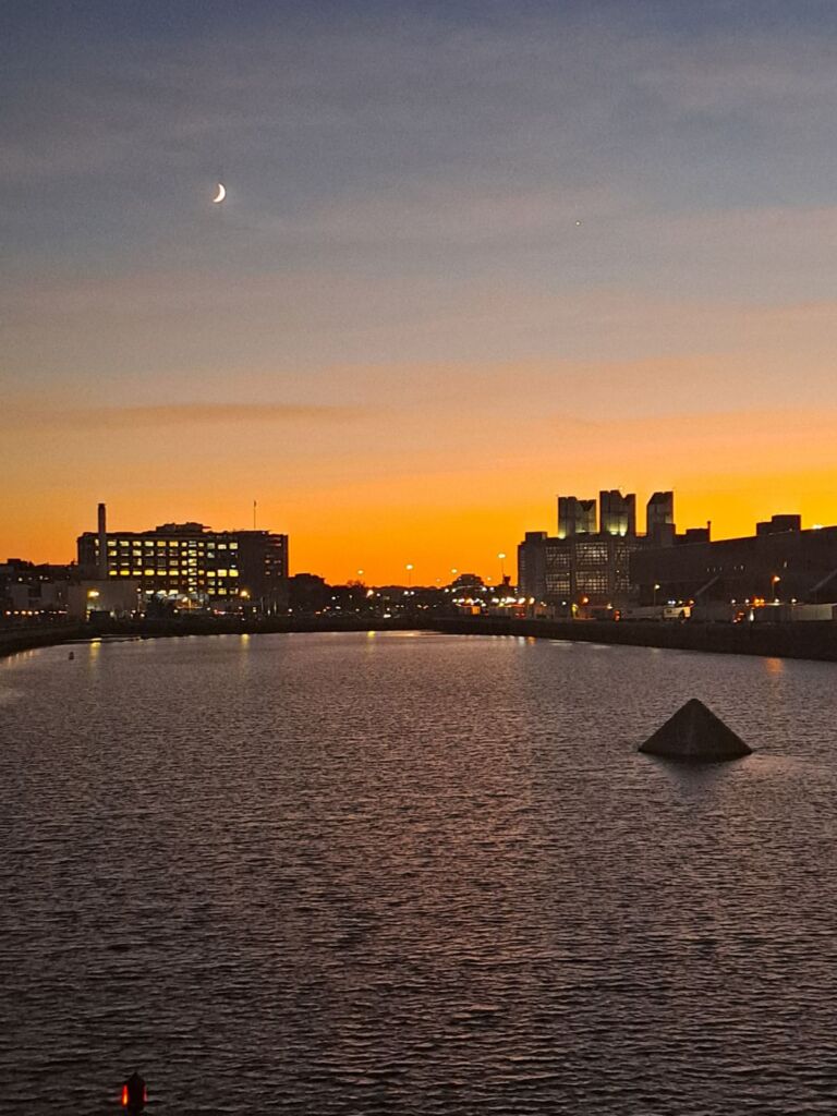 A photo of the Boston city skyline at sunset.